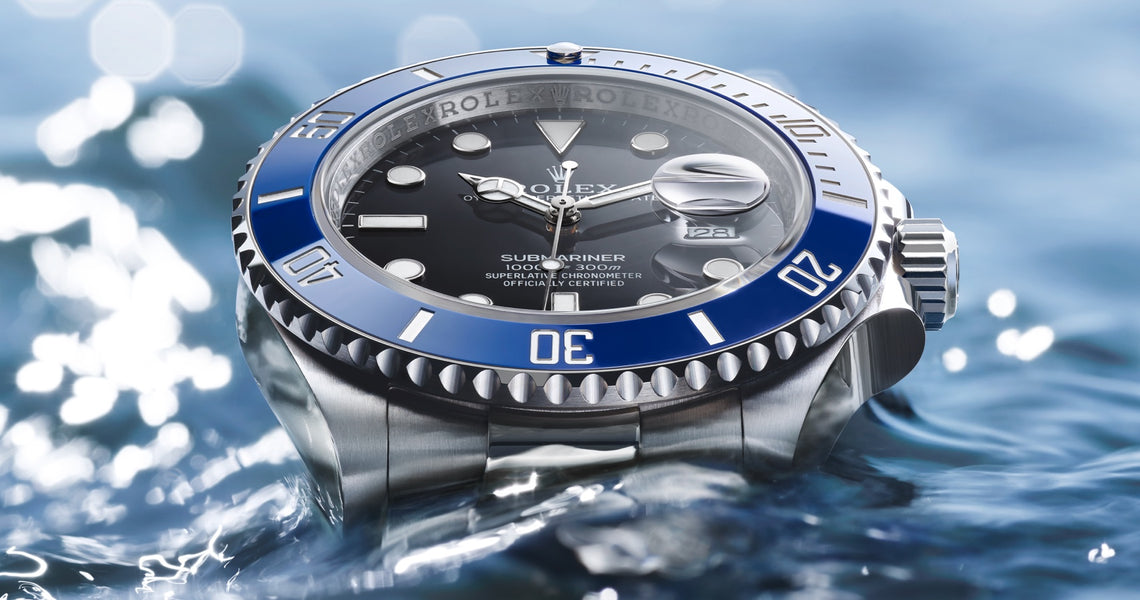 18K white gold Rolex Submariner date with a black dial and blue ceramic bezel. The watch head is resting above the water and the bracelet is underwater. Model #126619LB.