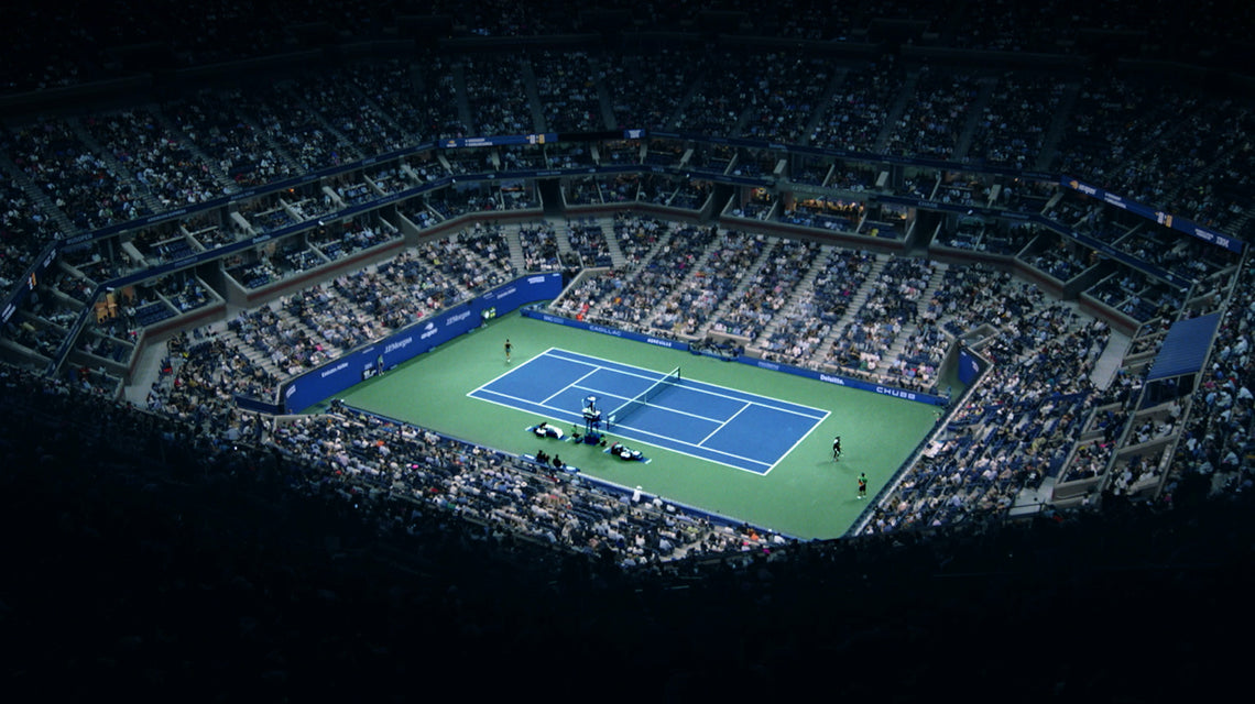 A birds eye view of the inside of a full Arthur Ashe stadium, watching 2 players in competition.