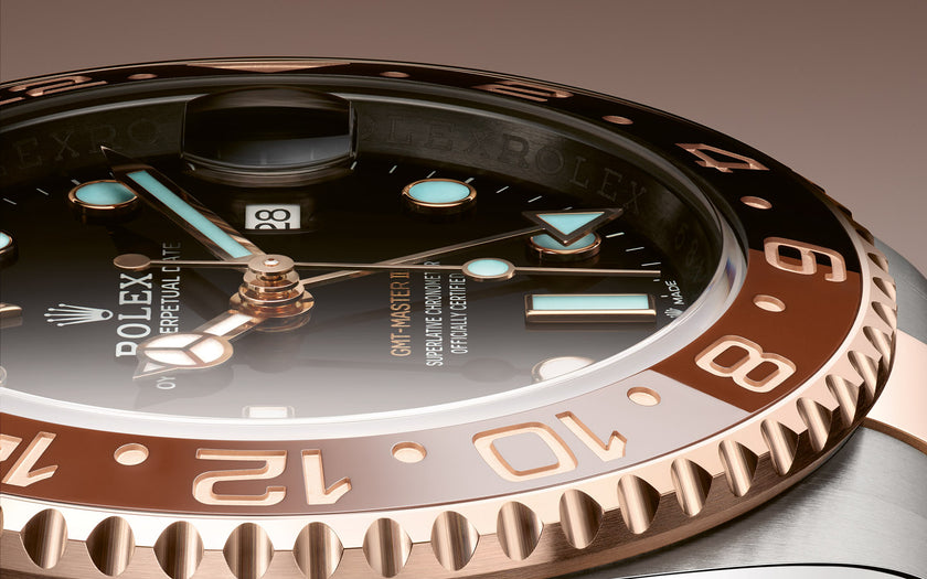 A close up view of the 18K Everose and Oystersteel Rolex GMT Master II, showing the brown and black ceramic insert on the bezel. Model #126711CHNR.