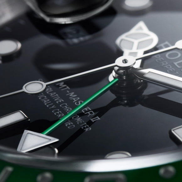 A close up angle of the Rolex GMT Master II showing the iconic green GMT hand. Model #126720VTNR.