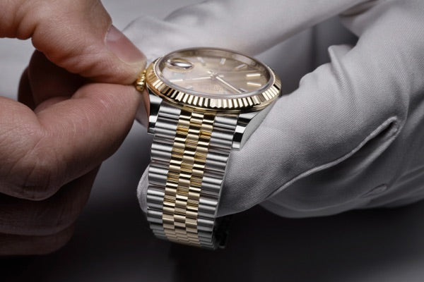 A service technician winding a Rolex Datejust.
