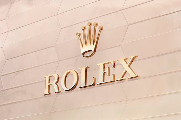 Rolex logo on a patterned wall.