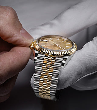 Rolex advisor holding a Rolex Datejust checking the crown.