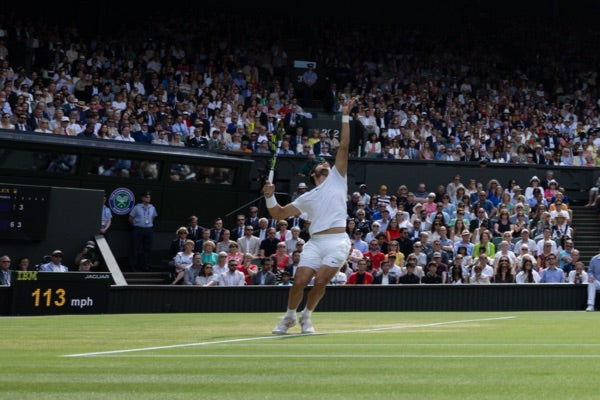 A tennis player serving the ball at Wimbledon.
