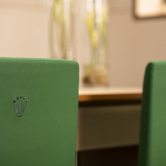 A close up of one of our green leather Rolex chairs. The Rolex crown is stitched into the back of the chair.