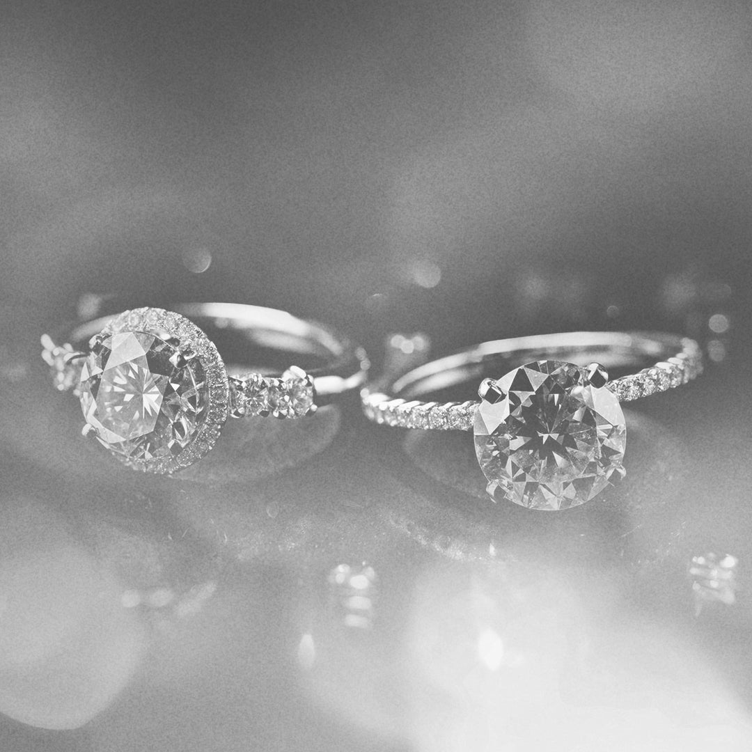 Rings and earrings lying on their sides on a teal background.