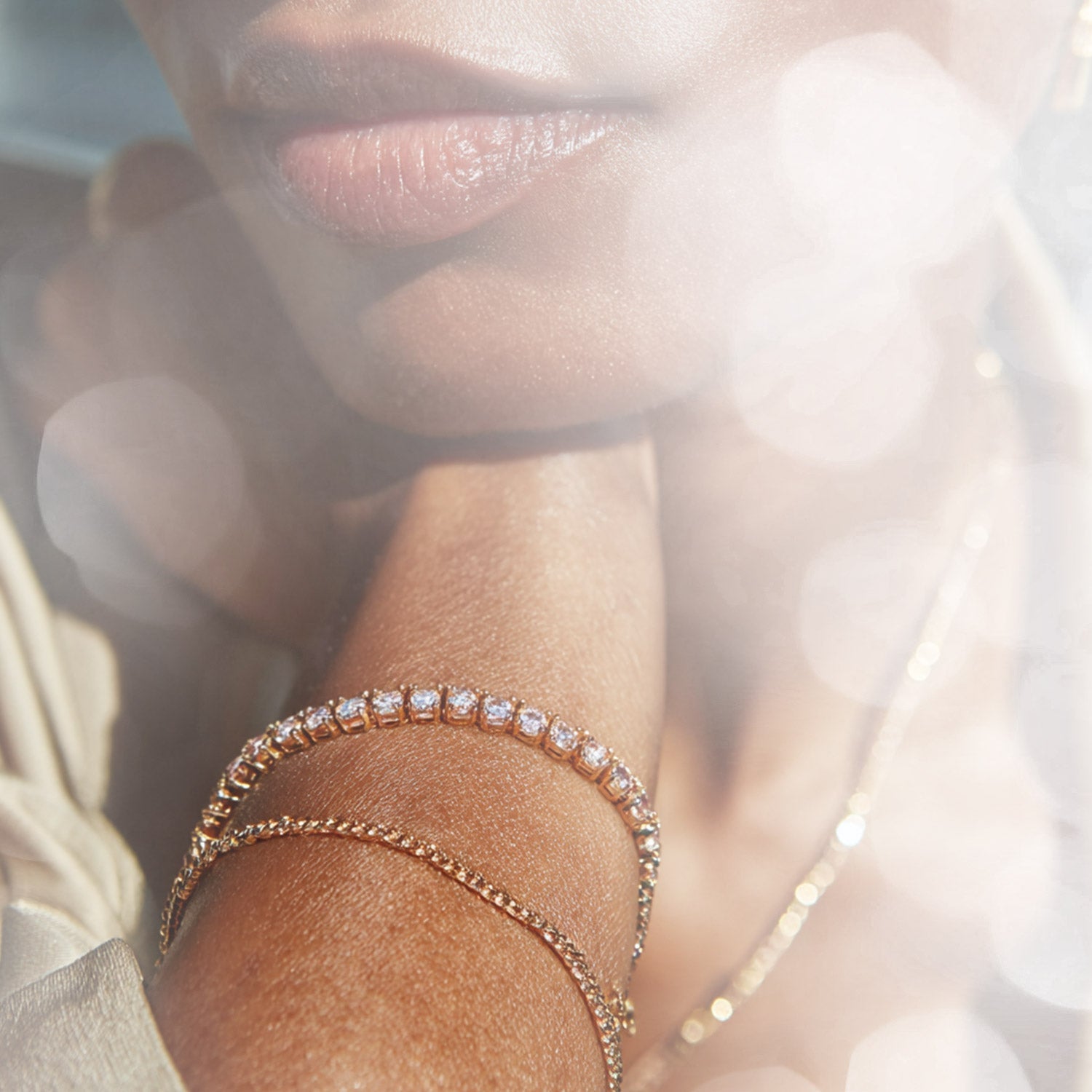 An intricate diamond bracelet on a woman's wrist with a teal background.