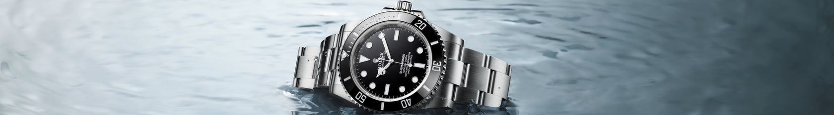 Rolex Submariner no-date lying on its side in the water, crown up. Model #124060.