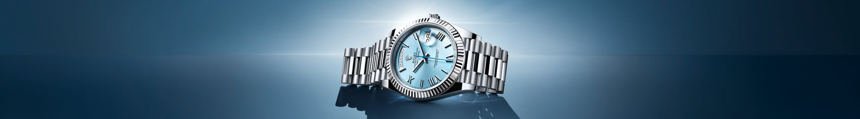 The platinum Rolex Day-Date 40 lying on its side. This 40mm watch is new for 2022 and features a new platinum fluted bezel and ice blue dial, unique to Rolex's platinum watches. Model #228236.