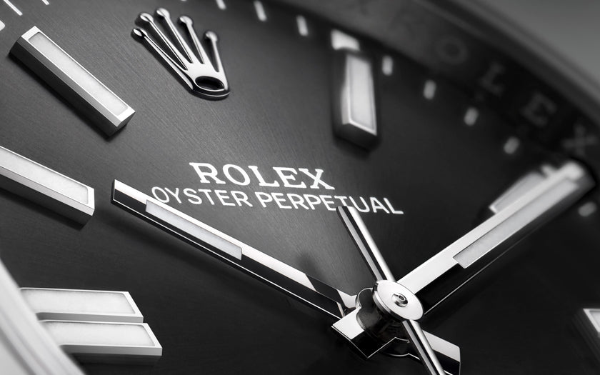 A close up shot of the black dial on the Rolex Oyster Perpetual 41 watch. The Rolex crown, and the words 