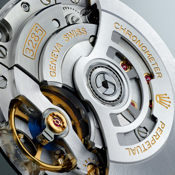 A close up image of the Rolex in-house produced and manufactured movement, calibre 3285. You get a glimpse of the blue parachrom hairspring and red paraflex shock absorbers.