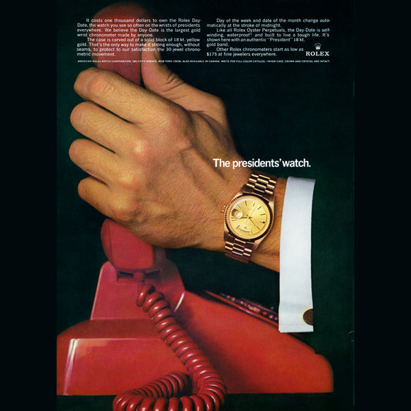A vintage Rolex ad showing a hand with a Rolex Day-Date on the wrist, answering a red telephone. Many political figures wear the Rolex Day-Date and it has become known as the 