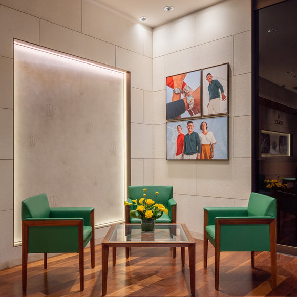 Our Rolex sitting area which features a glass table and 3 custom-made chairs in green leather.