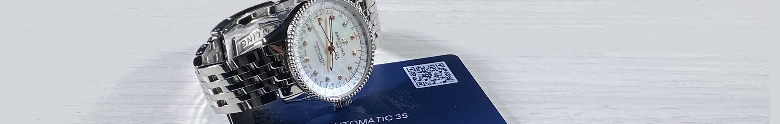 Pre-owned Breitling Navitimer 35 lying on its warranty card.